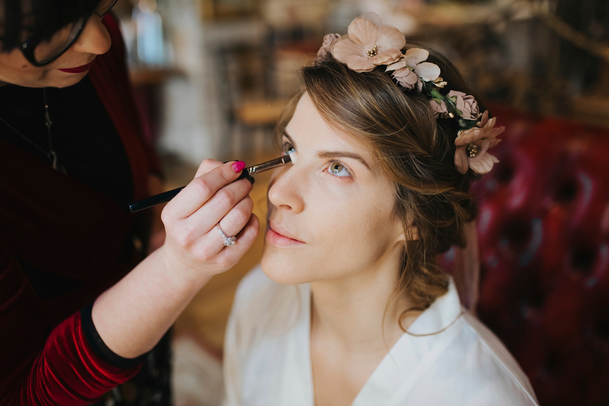 Bride preparing for wedding with make-up artist